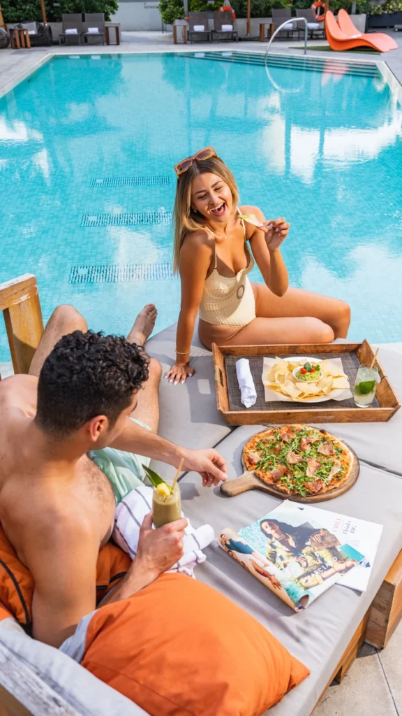 couple eating pizza in the pool